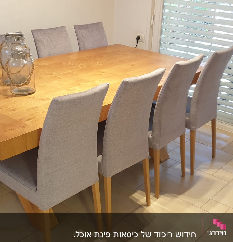 שולחן עץ עם כיסאות מרופדים בצבע אפור